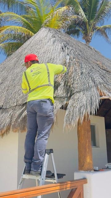 Técnico instalando un access point en una palapa